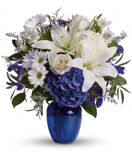 In this arrangement, the serenity of the color blue along with the purity of intention symbolized by white will let the family know you are sending your calm strength to them during these difficult times.