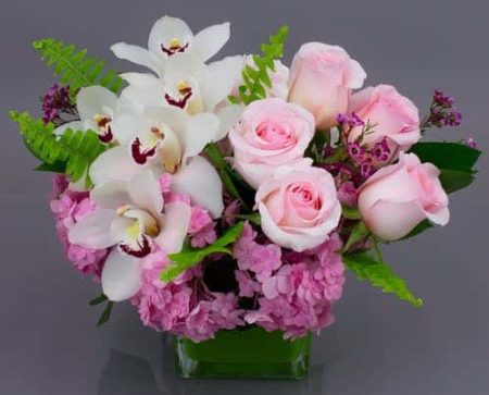 One of our best sellers, the Gentle Embrace is a sweet vase perfect for almost any occasion. It's compact design style makes it the perfect gift for home or office. The soft and subtle colors are easy on the eye and complement any decor. We've collected beautiful hydrangea, farm fresh premium roses and elegant cymbidium orchids and designed them in our signature cubes for easy transport. Small - perfect for a desk or end table Large - better for special occasions