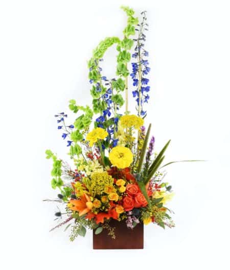 Seasons change arrangement includes colorful autumn flowers and greenery in brown box