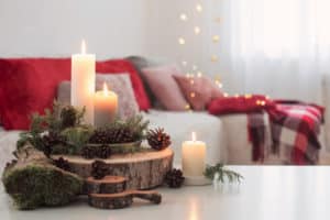 Composition of candles on  white table against the background of sofa at home